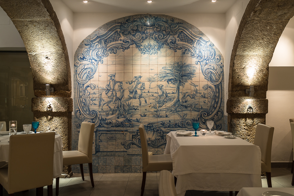 Sala de jantar em arco com parede de azulejos azuis e brancos