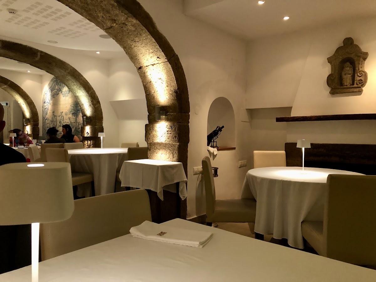 Round tables under historic stone archways in the dining room