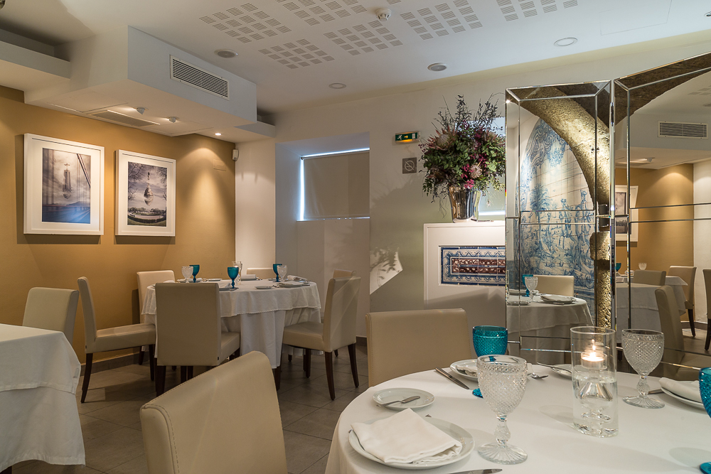 Wide view of the main dining room with set tables and framed art